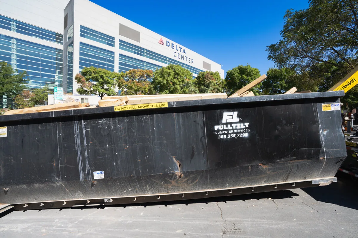 Full Tilt branded roll-off container at a project site